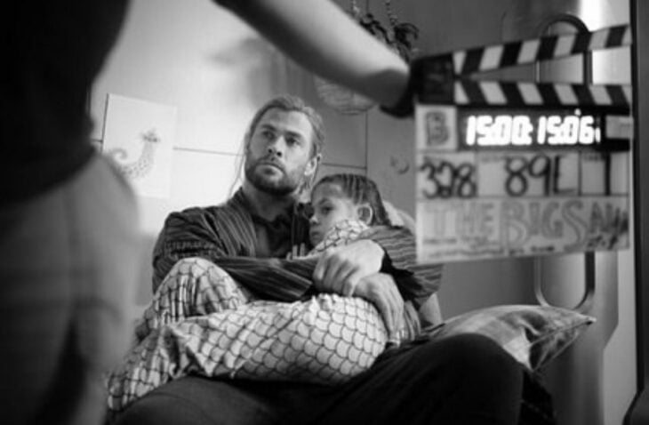 Chris Hemsworth cargando a su hija sentado en el set de grabación de la película de THor: Amor y Trueno 