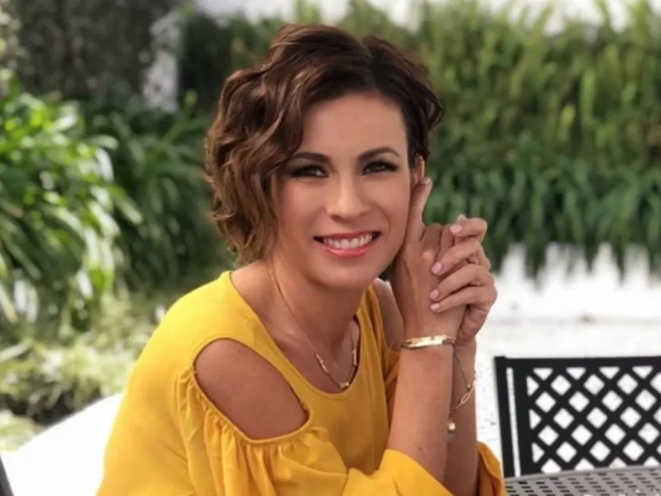 Ingrid Coronado posa sonriente sentada en la mesa de un restaurante al aire libre