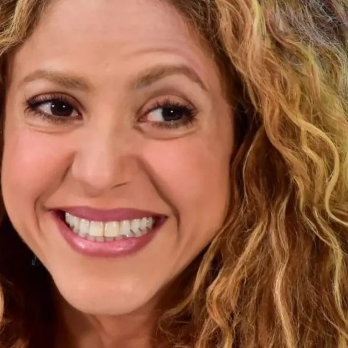 Shakira muestra una sonrisa forzada lleva el cabello suelto con rizos