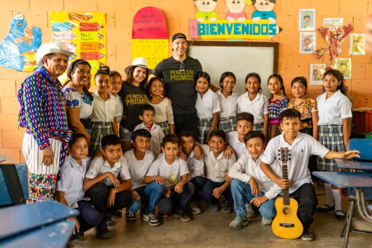 Martha Higareda y Lewis Howes en Guatemala posan con maestros y alumnos de una escuela en un salón de clases