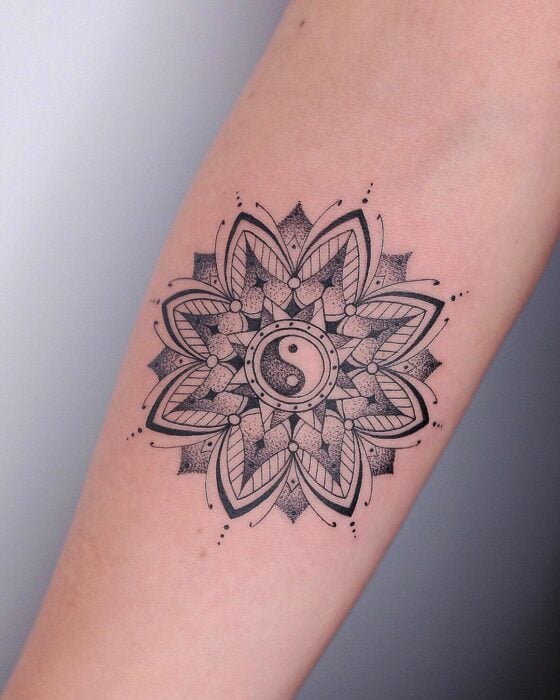 tatuaje con el diseño de una mandala con un símbolo de Ying Yang en el centro 