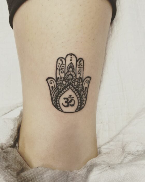 tatuaje de una mano de Fátima con unas letras en Árabe 
