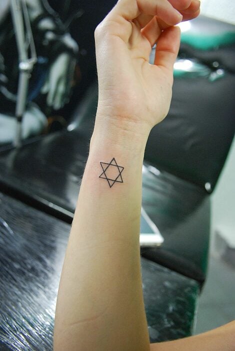 tatuaje con un pequeño símbolo de estrella de cinco puntas 