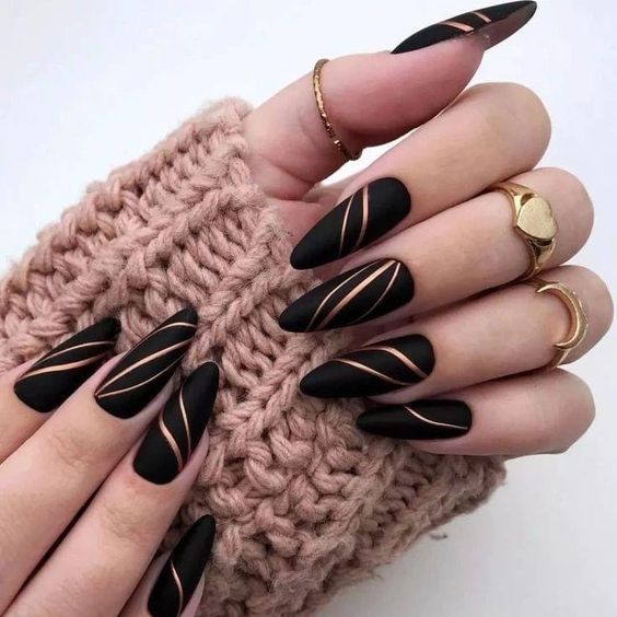 Manicura en color negro con franjas doradas 