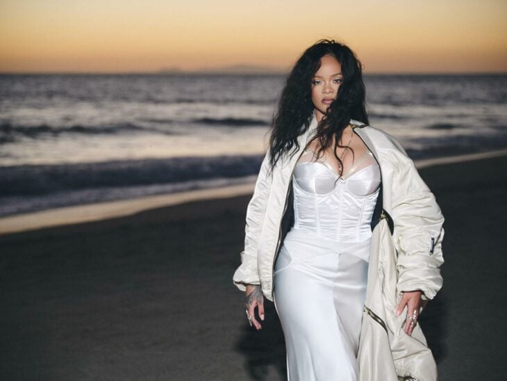 Rihanna posando en vestido blanco a la orilla del mar 