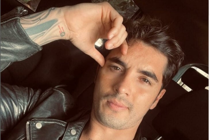el modelo Christian Estrada posa con la mano en la frente tiene un tatuaje en el brazo