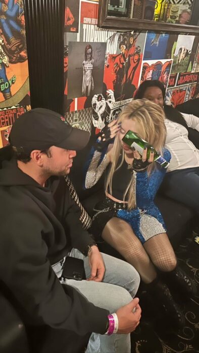 ava max sosteniendo una botella en su frente por el golpe 