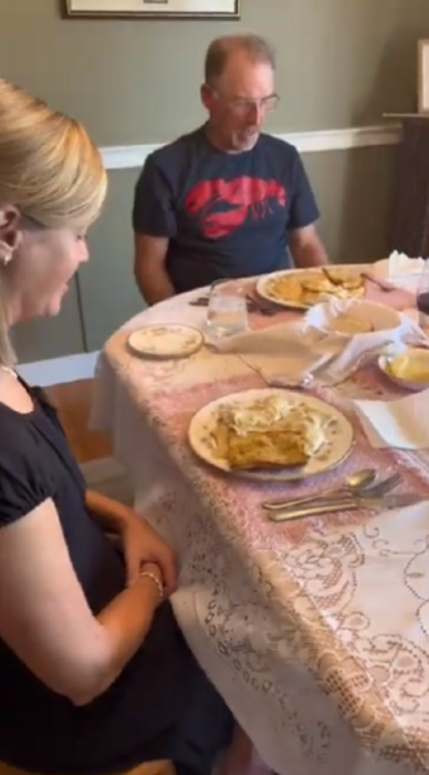 una pareja observa sus platos con alimentos asombrados mientras están sentados en la mesa