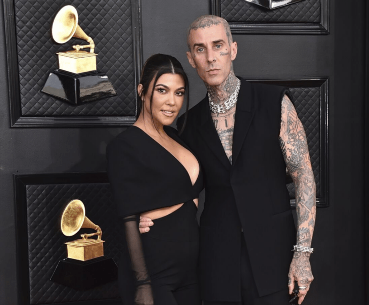 Kourtney Kardashian y Travis Barker posan en la alfombra roja de los premios Grammys ambos van vestidos de color negro