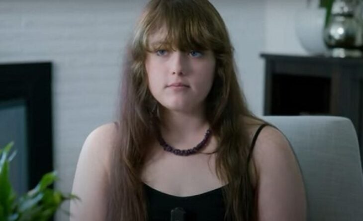 una chica lleva el cabello suelto y despeinado combina con una blusa de tirantes negra 