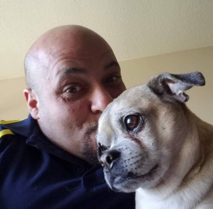 Mike Batayeh besando a su perro en la cabeza 