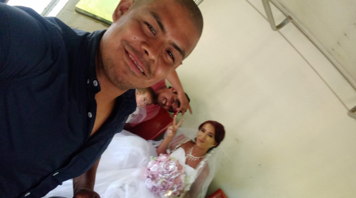 un hombre toma una selfie en el camión para fotografiar a una mujer vestida de novia que va sentada en los asientos