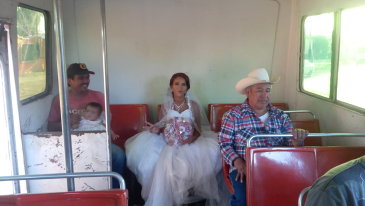 una novia sentada en los asientos de atrás de un camión de transporte público