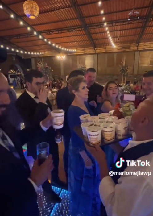 invitados de una boda felices tomando las sopas maruchan que el mesero les ofrece