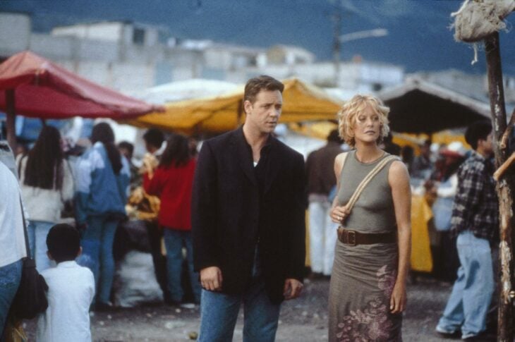 Russell Crowe y Meg Ryan en una escena de Prueba de vida rodeados de varios extras