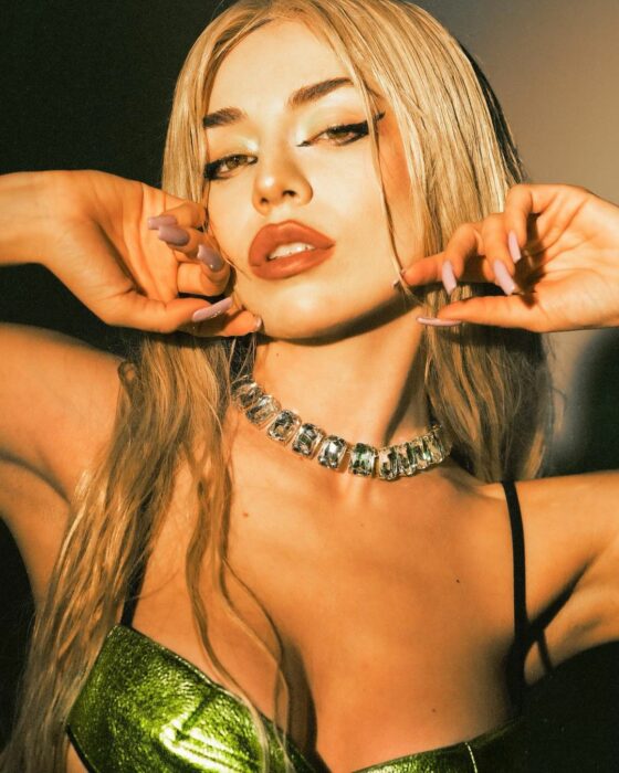 Ava Max posando para foto con las manos en el rostro