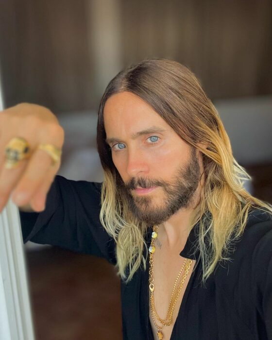 Jared Leto con camisa negra recargado en su brazo 