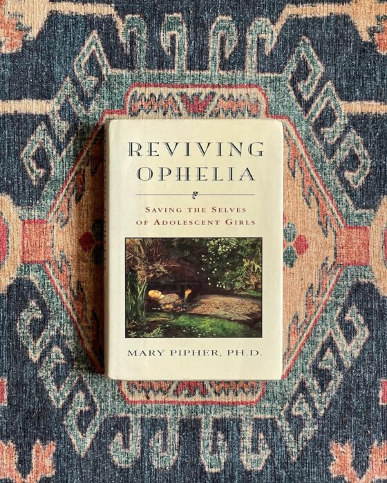 libro Reviving Ophelia sobre un tapete de colores 