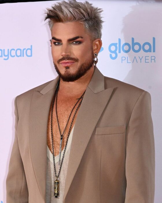 Adam Lambert con saco color café en un evento 