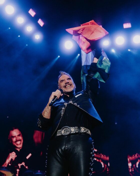 Alejandro Fernandez con la bandera de méxico en un concierto 