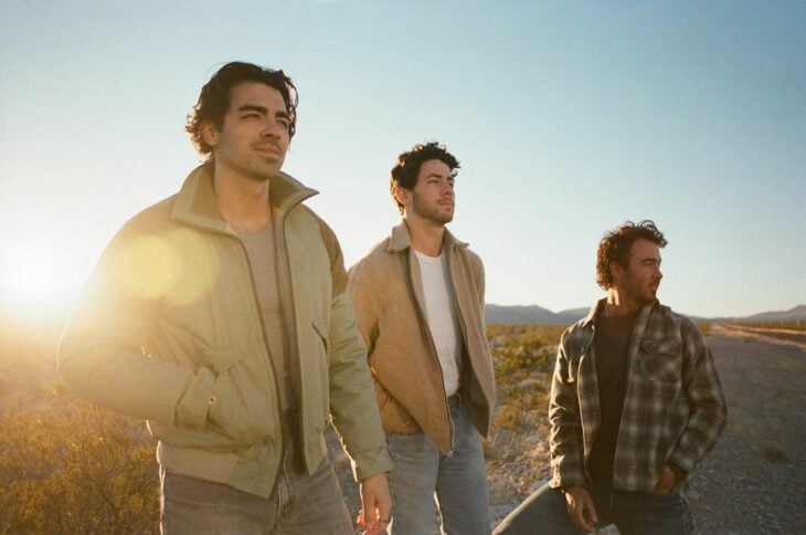 Los Jonas Brothers en un paisaje con atardecer 