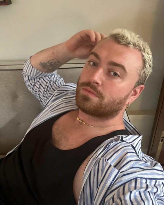 Sam Smith con camisa y playera negra de tirantes 