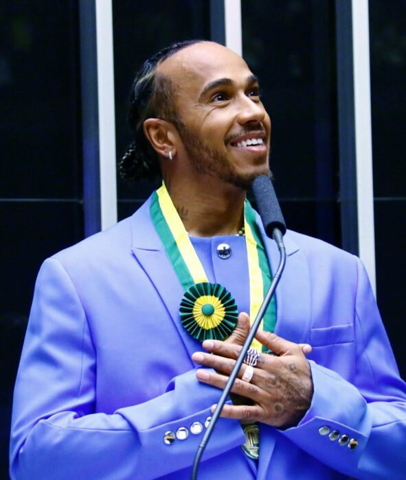 Lewis Hamilton posando con un traje en color morado 