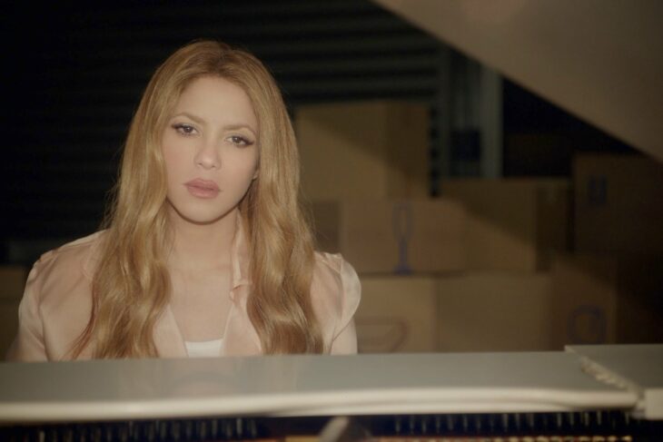 Imagen de Shakira sentada frente a un piano en el video de su tema Acróstico 
