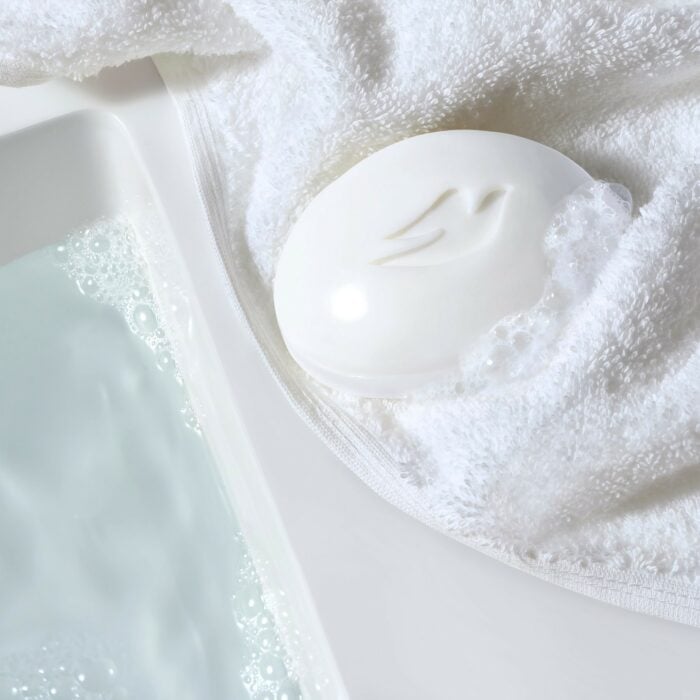 Imagen de un jabón Dove sobre una toalla blanca 
