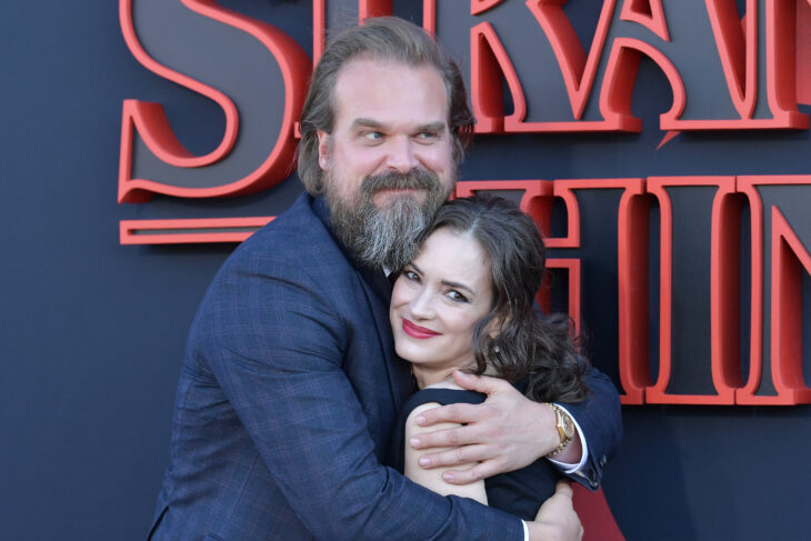 David Harbour con Winona Ryder abrazados en alfombra roja 