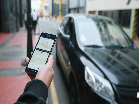 mano de una persona pidiendo taxi en el celular 