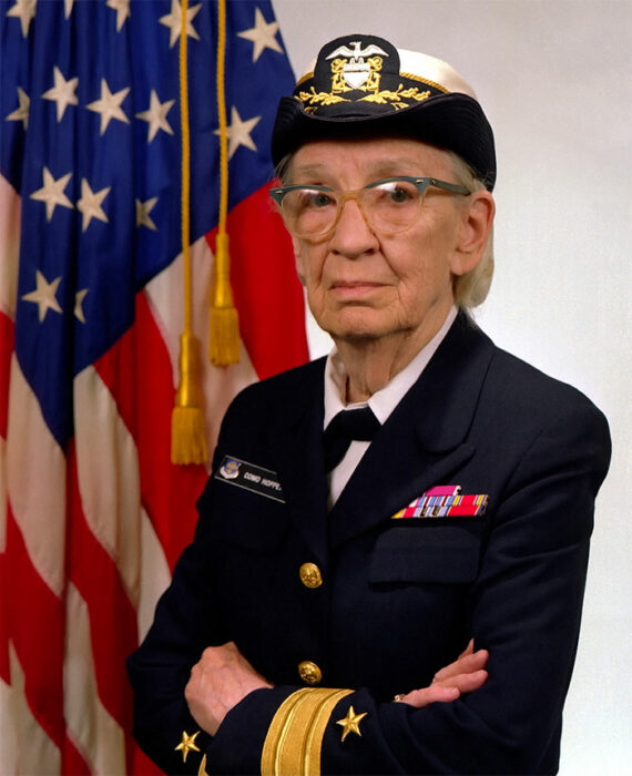 Grace Hopper de miltar con la bandera de estados unidos 