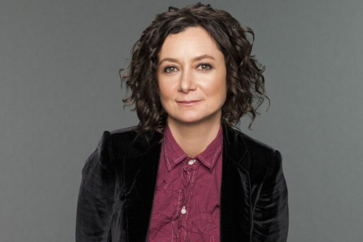 Sara Gilbert con blusa morada y saco negro 