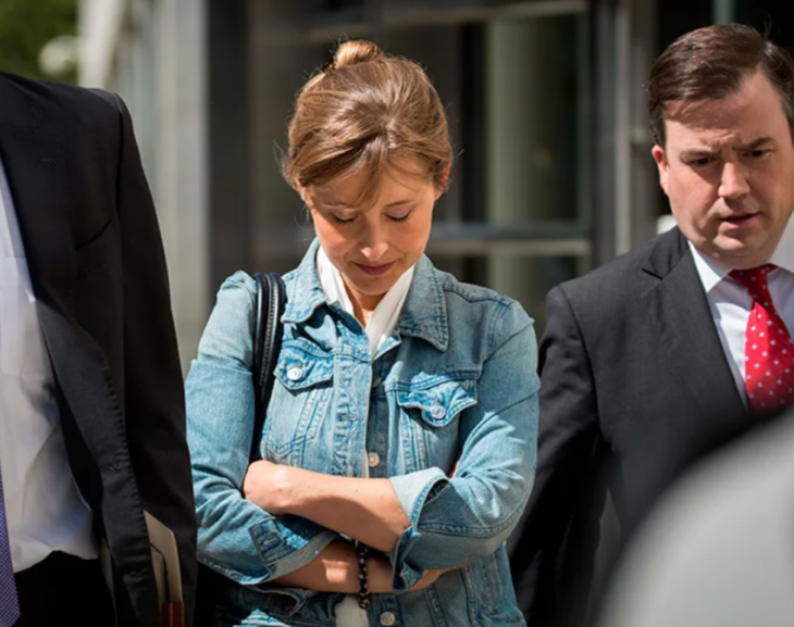 Allison Mack camina junto a su equipo de abogados con la cabeza baja y los brazos cruzados al frente en clara actitud de vergüenza 