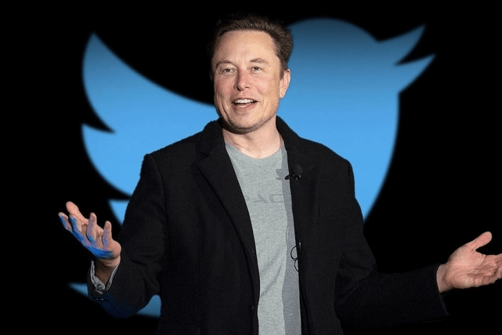 Elon Musk posando frente a un emoji de Twitter 