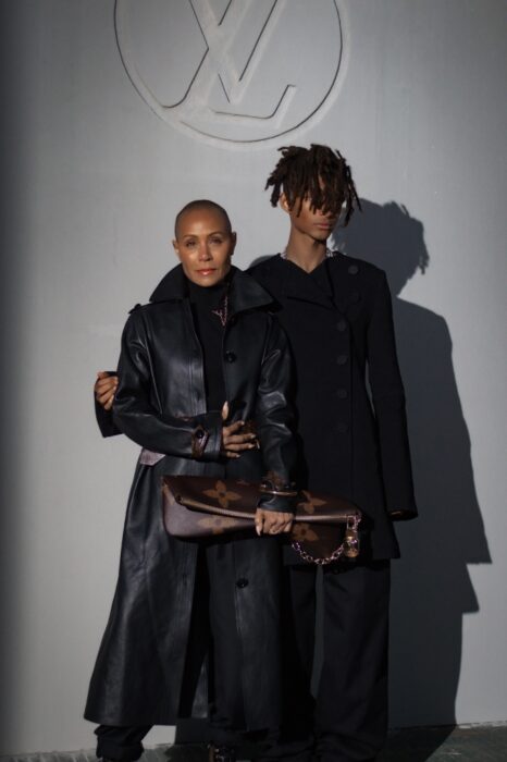 Jaden Smith posando vestido de negro al lado de su madre Jada Pinkett 