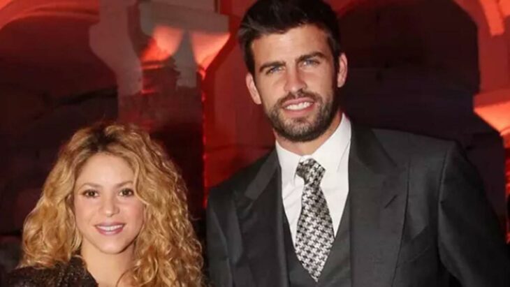 Shakira y Gerard Piqué sonríen felices en un evento ella lleva el cabello suelto y chino él lleva un traje con corbata gris