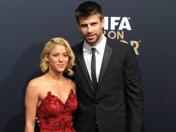Shakira y Gerard Piqué en la alfombra roja de un evento de la FIFA ella lleva un vestido rojo de noche y él traje y corbata negros 