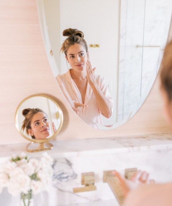 Mujer haciendo rutina de skincare frente al espejo circular
